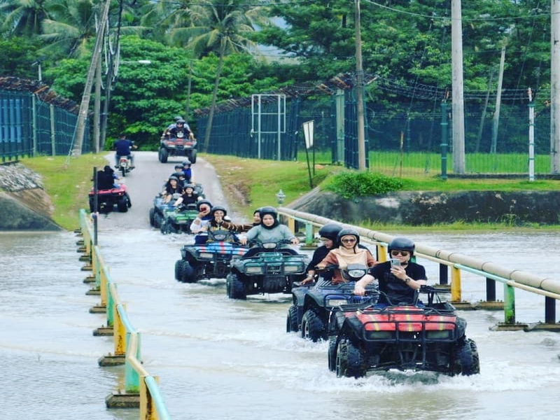 Tourists riding ATv through water road at ATV Adventure Ride Langkawi